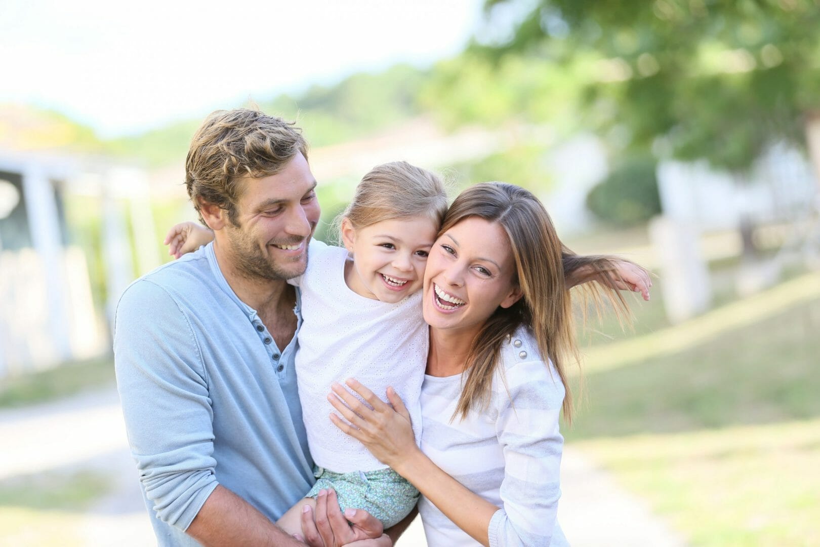 Happy family outdoors smiling and hugging
