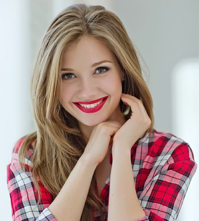 Smiling woman with red lipstick in plaid shirt
