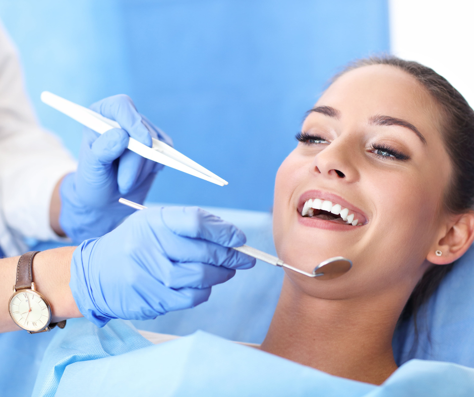 Woman smiling at dental checkup, dentist tools visible